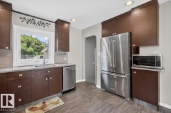 Kitchen featuring wood-finish cabinetry, stainless steel appliances, light-toned countertops, and a subway tile backsplash - 