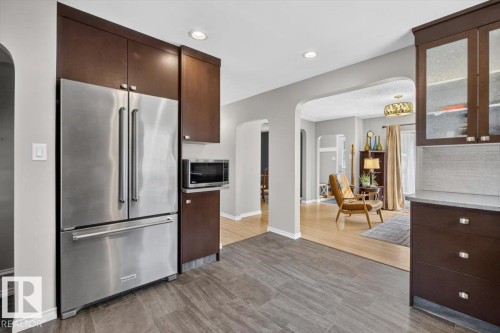 Modern kitchen featuring dark wood cabinetry and stainless steel appliances - 11934 43 Street Nw, Edmonton, AB - Indoor Photo Showing Kitchen