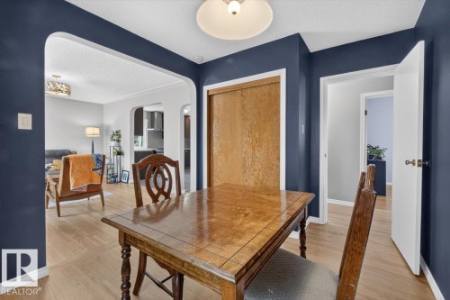 Dining space featuring rich navy walls and wood-finish flooring - 11934 43 Street Nw, Edmonton, AB - Indoor Photo Showing Dining Room