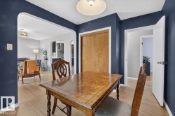 Dining space featuring rich navy walls and wood-finish flooring - 