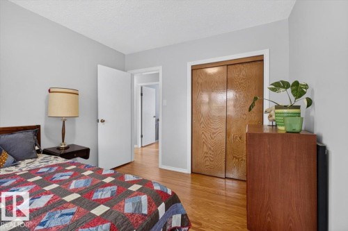 Neutral wall color with wood-finish flooring - 11934 43 Street Nw, Edmonton, AB - Indoor Photo Showing Bedroom