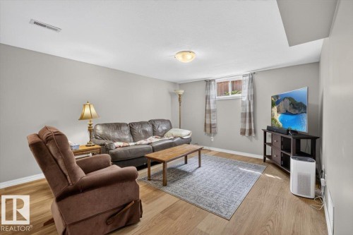 Recreation room featuring wood-finish flooring, light grey walls, a recessed window, and a ceiling-mounted light fixture - 11934 43 Street Nw, Edmonton, AB - Indoor Photo Showing Other Room