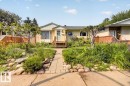 Front exterior featuring a light-colored facade, pitched roofline, and a wooden front porch - 11934 43 Street Nw, Edmonton, AB  - Outdoor 