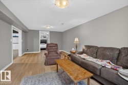 Open concept living area featuring light wood-finish flooring, neutral gray walls, and white baseboards - 