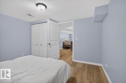 Room featuring wood-finish flooring, a bi-fold closet with white paneled doors, and light blue wall tones - 