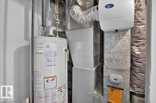 Utility space featuring a water heater, furnace system, ductwork, and an attached humidifier unit - 11934 43 Street Nw, Edmonton, AB - Indoor Photo Showing Basement