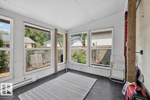 Enclosed porch featuring multiple windows, dark tile flooring, and unfinished drywall walls and ceiling - 11934 43 Street Nw, Edmonton, AB - Indoor Photo Showing Other Room