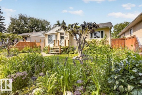 Landscaped front yard with mature garden beds and a central lawn - 11934 43 Street Nw, Edmonton, AB - Outdoor