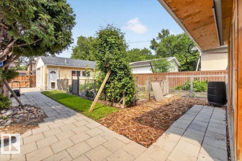 Paved stone pathway leading to a detached garage with a white door - 11934 43 Street Nw, Edmonton, AB - Outdoor