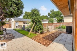 Paved stone pathway leading to a detached garage with a white door - 