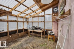 Greenhouse structure featuring a wood frame, translucent roof, and window panels - 
