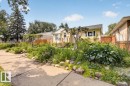 Front exterior featuring a yellow stucco finish, white trim, and a gray shingle roof - 11934 43 Street Nw, Edmonton, AB  - Outdoor 