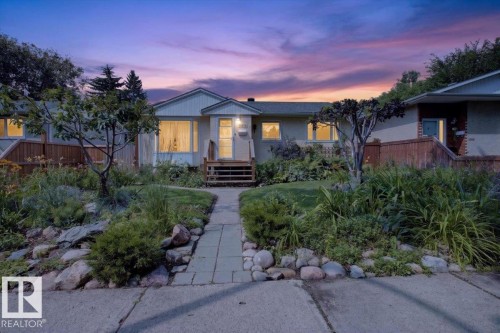 Front exterior featuring a pedestrian sidewalk, a stone-edged paver pathway, mature plantings, and exterior siding - 11934 43 Street Nw, Edmonton, AB - Outdoor With Facade