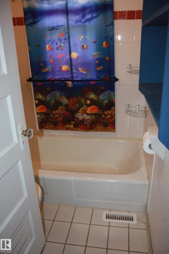 White tile flooring and bathtub surround - 5227 51 Street, Redwater, AB - Indoor Photo Showing Bathroom