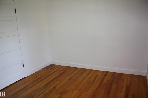 Hardwood flooring complemented by white baseboards and neutral wall tones - 5227 51 Street, Redwater, AB - Indoor Photo Showing Other Room