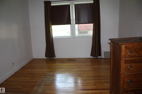 Hardwood flooring throughout a room with white walls and baseboards - 5227 51 Street, Redwater, AB - Indoor Photo Showing Other Room