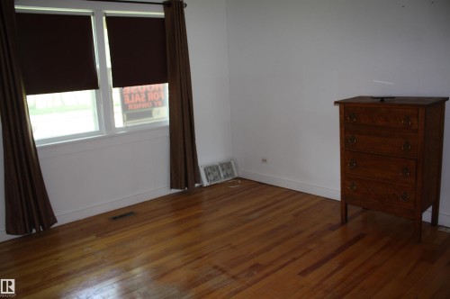 Room featuring wood-finish flooring, white baseboards, and white painted walls - 5227 51 Street, Redwater, AB - Indoor Photo Showing Other Room