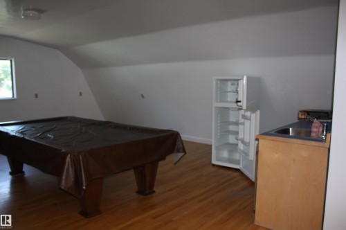 Hardwood-style flooring throughout this versatile space - 5227 51 Street, Redwater, AB - Indoor Photo Showing Other Room