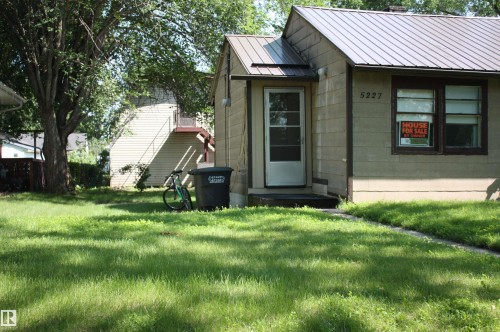 Exterior residence with light-colored siding and a dark metal roof - 5227 51 Street, Redwater, AB - Outdoor