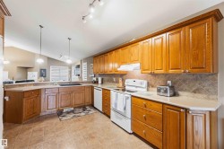Kitchen featuring extensive wood cabinetry, tile flooring, and a tile backsplash - 