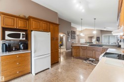 Kitchen featuring wood cabinetry, light-toned countertops, and tile flooring - 