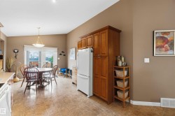 Eat-in kitchen featuring tile flooring, oak cabinetry, and direct patio access - 