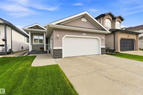 Exterior features include horizontal siding with stone accents, a prominent front garage, a covered entryway, and a concrete driveway - 6320 166 Avenue Nw, Edmonton, AB - Outdoor With Facade