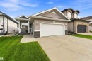 Exterior features include horizontal siding with stone accents, a prominent front garage, a covered entryway, and a concrete driveway - 6320 166 Avenue Nw, Edmonton, AB  - Outdoor With Facade 