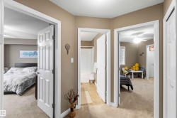 Hallway featuring neutral-toned walls, white trim, and carpeted flooring - 