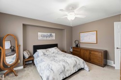 Recessed wall niche, neutral wall tones, textured carpeting, and a ceiling fan with integrated lighting - 