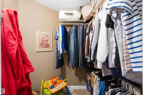 Walk-in closet featuring carpet flooring, neutral wall paint, and white baseboards - 6320 166 Avenue Nw, Edmonton, AB - Indoor With Storage