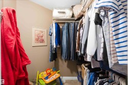 Walk-in closet featuring carpet flooring, neutral wall paint, and white baseboards - 