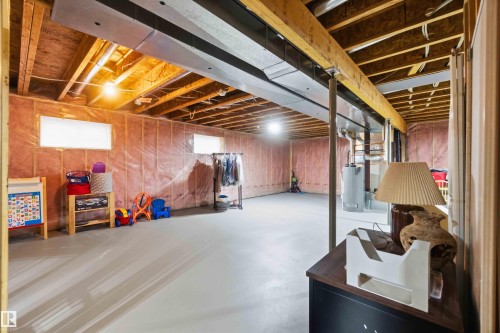 Expansive unfinished basement featuring an open floor plan, concrete flooring, exposed ceiling joists, and visible insulation along perimeter walls - 6320 166 Avenue Nw, Edmonton, AB - Indoor Photo Showing Basement