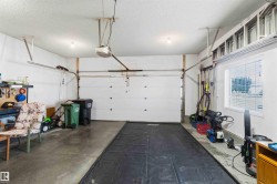 Spacious garage featuring a concrete floor, overhead lighting, and a window with blinds - 