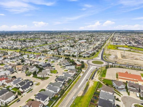 Expansive aerial landscape highlighting a developed residential area with numerous single-family homes and a prominent roundabout - 6320 166 Avenue Nw, Edmonton, AB - Outdoor With View