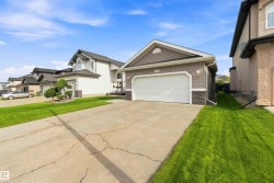 Contemporary exterior featuring horizontal siding, stone veneer accents, an attached garage with a white door, and a concrete driveway - 
