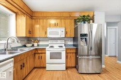 Kitchen featuring wood-finish cabinetry, stainless steel French door refrigerator, white electric range, and a double basin stainless steel sink with a high-arc faucet - 