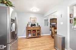 Expansive wood-finish flooring throughout, complemented by light gray wall tones and white baseboards - 