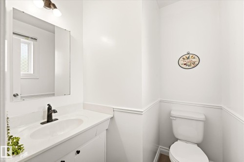 White bathroom vanity with an integrated sink and dark bronze faucet - 4921 47 Avenue, Legal, AB - Indoor Photo Showing Bathroom