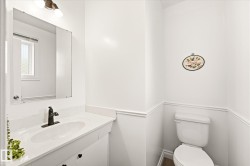 White bathroom vanity with an integrated sink and dark bronze faucet - 