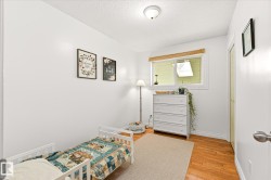 Bright room featuring a window with wood-finish trim, a flush-mount ceiling light, wood-finish flooring, and a bifold closet door - 