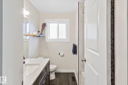 Bathroom featuring a dark wood-finish vanity with an integrated sink, white countertop, and contemporary hardware - 