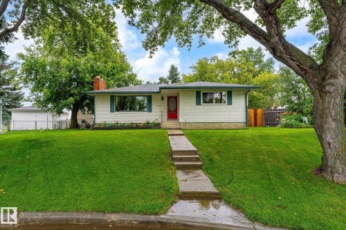 White siding exterior with a vibrant red entry door and green window shutters - 4921 47 Avenue, Legal, AB - Outdoor