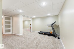 Spacious carpeted room featuring recessed lighting, a drop ceiling, and light-toned walls - 