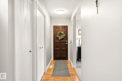 Entryway featuring wood-finish flooring, a paneled front door, white louvered bifold closet doors, and recessed ceiling lighting - 4921 47 Avenue, Legal, AB - Indoor Photo Showing Other Room