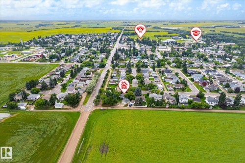 Aerial perspective showcasing a residential community surrounded by expansive agricultural fields - 4921 47 Avenue, Legal, AB - Outdoor With View