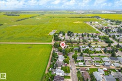 Aerial overview of a residential neighborhood with surrounding green fields - 