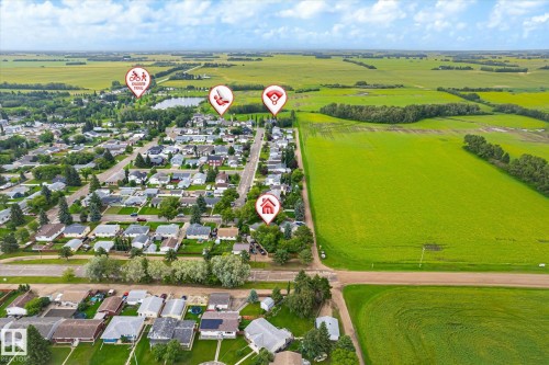 Aerial perspective of a residential area surrounded by expansive green fields - 4921 47 Avenue, Legal, AB - Outdoor With View