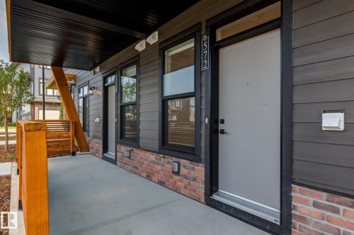 Contemporary exterior featuring dark horizontal siding, red brick accents, and black trim - #1 16231 19 Av Sw, Edmonton, AB - Outdoor With Exterior