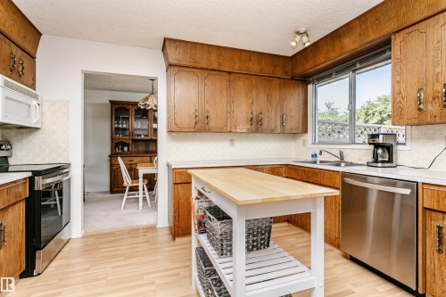 Kitchen featuring wood cabinetry, light-toned countertops, and a window above the sink - 18316 78 Avenue Nw, Edmonton, AB - Indoor Photo Showing Kitchen With Double Sink
